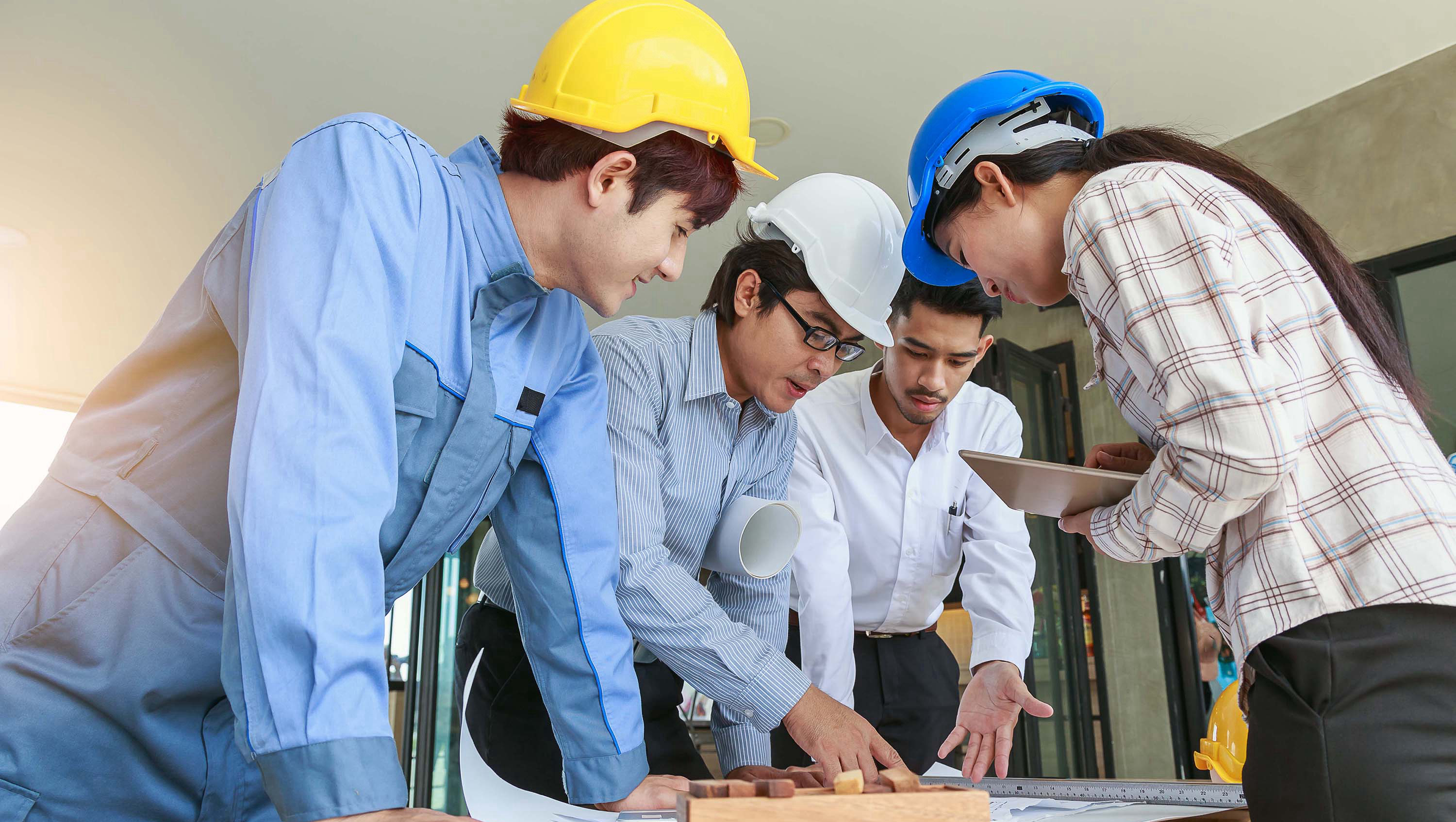 Engineer team looking paper plans at construction site